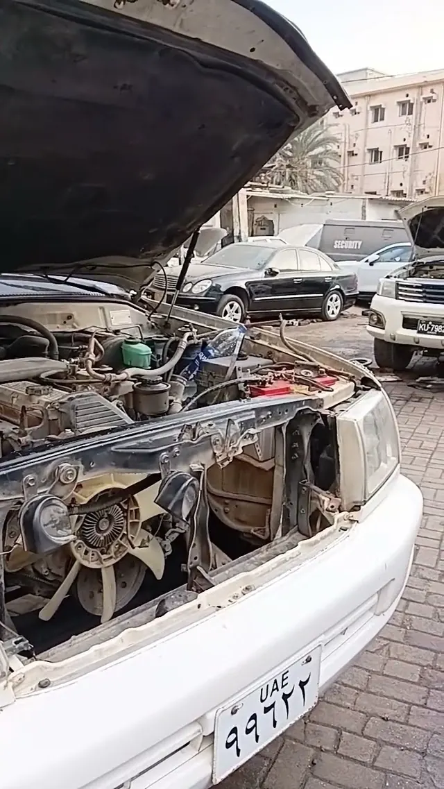 A Land Cruiser with its front opened up for AC condenser work