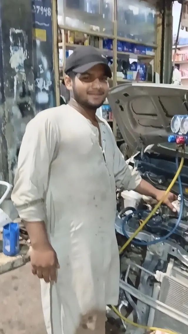A Mian Autos mechanic checking a car's AC with pressure gauges