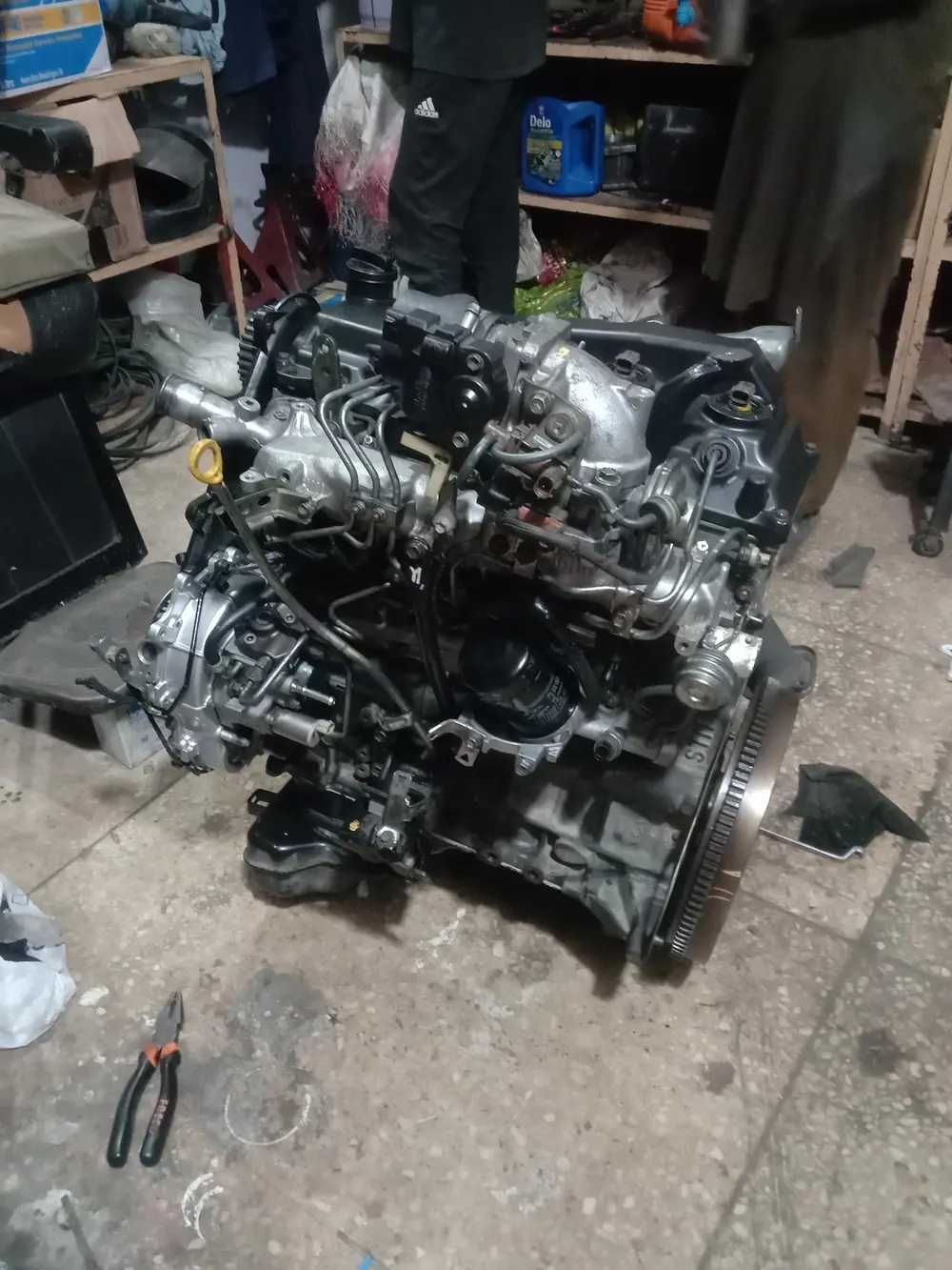 A mechanic working on an engine at Mian Autos