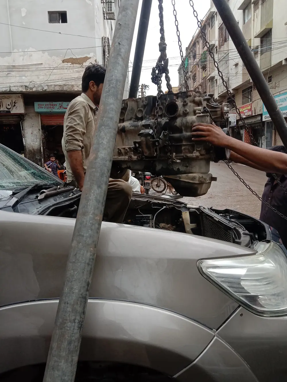 An engine lifted out on a chain hoist at the workshop