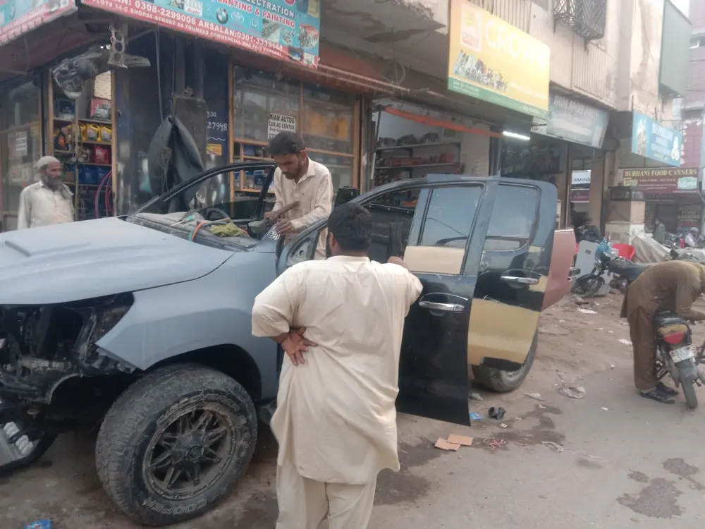 Mechanics working on a car outside Mian Autos on Street 24